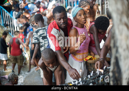 La gente adora alla base di un albero nel corso del Saut D'eau festival Voodoo in Haiti il 15 luglio 2008. Foto Stock