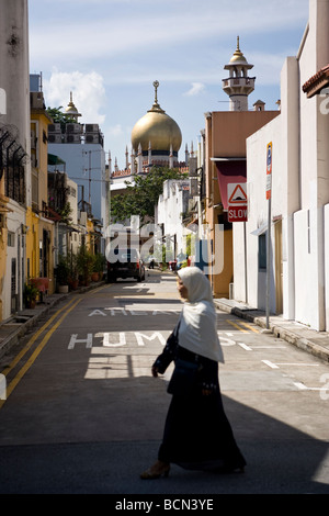 Una donna musulmana cammina giù per una strada nel quartiere musulmano noto anche come Kampong Glam di Singapore Foto Stock