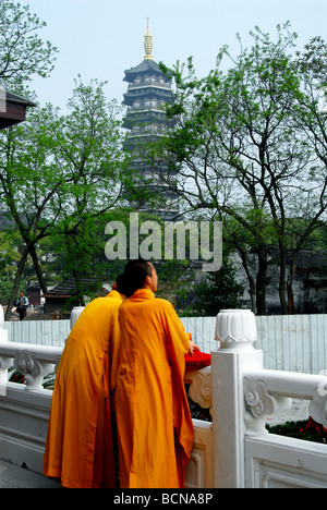 Due giovani monaci di prendere un periodo di riposo contro la ringhiera di marmo nel Tempio Longhua, Shanghai, Cina Foto Stock