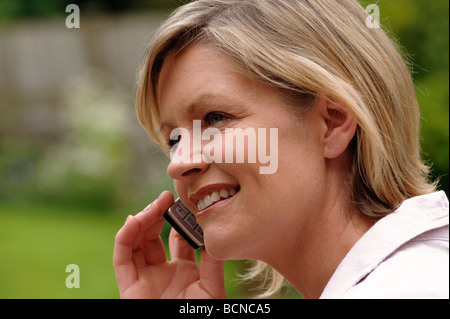 Donna che utilizza un telefono mobile Foto Stock