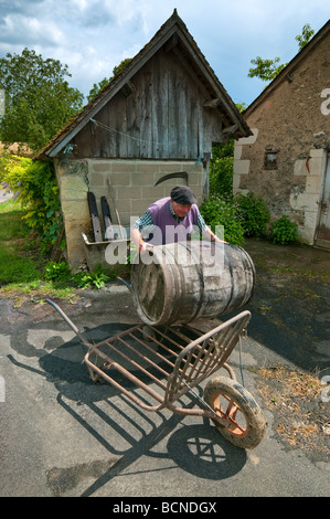 Agricoltore il caricamento di botte di vino sul camion - sud-Touraine, Francia. Foto Stock