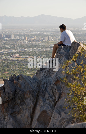 Un escursionista guarda verso il basso dalla sommità del picco Piestewa (ex Squaw Peak) nelle montagne di Phoenix preservare, Phoenix, Arizona, Stati Uniti d'America Foto Stock