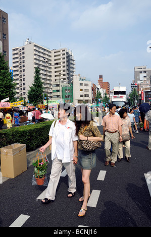 Coppia giapponese che cammina per strada, Tokyo, Giappone Foto Stock