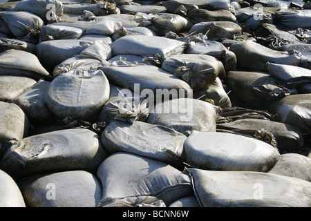 I sacchi di sabbia usati come barriera sulla riva del mare Foto Stock