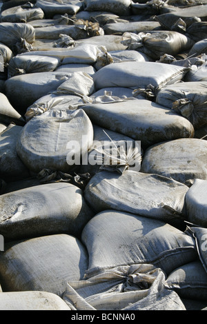 I sacchi di sabbia usati come barriera sulla riva del mare Foto Stock