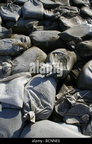 I sacchi di sabbia usati come barriera sulla riva del mare Foto Stock