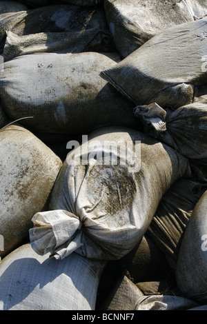 I sacchi di sabbia usati come barriera sulla riva del mare Foto Stock