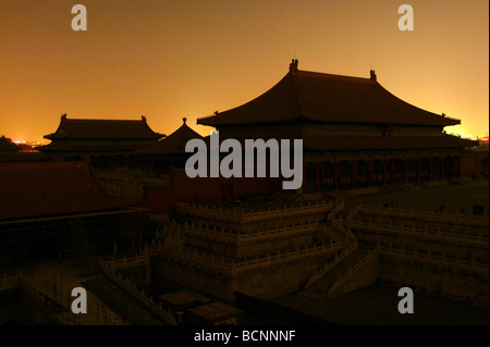 Tre sale principali nella corte esterna della città proibita circondato da laminazione delle luci della città di notte, Pechino, Cina Foto Stock