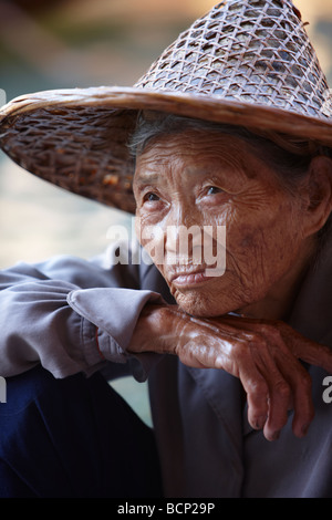 Ritratto di un uomo tailandese su una barca al mercato galleggiante di Damnoen Saduak, nr Bangkok, Thailandia Foto Stock