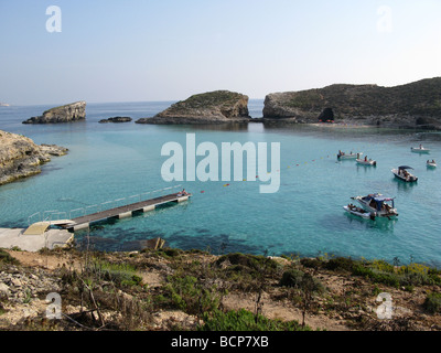Imbarcazioni da diporto e imbarcazioni in laguna blu con Cominotto c al di là, Comino, Isola Maltese, Malta, Mediterraneo, Europa Foto Stock