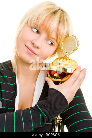 Junge Frau in Sportkleidung umarmt einen Pokal Foto Stock