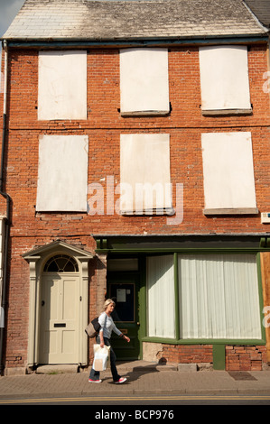 Donna camminare davanti a un intavolato edificio nel centro della città di Hereford Herefordshire England Regno Unito Foto Stock