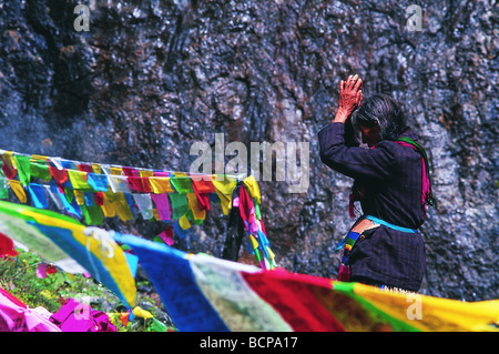 Anziano tibetano donna orante di fronte Yubeng Shenpu sul percorso interiore di pellegrinaggio intorno al monte Kawa Dampa, Meili Snow Foto Stock