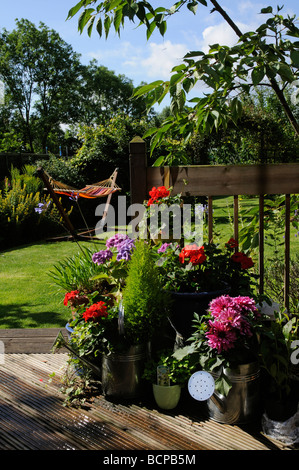 Suburban English country garden coloratissimi fiori e piante disposte sul decking area Foto Stock