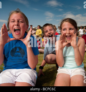 I bambini gridando a sostegno del loro team di casa in una scuola primaria la giornata dello sport UK Foto Stock