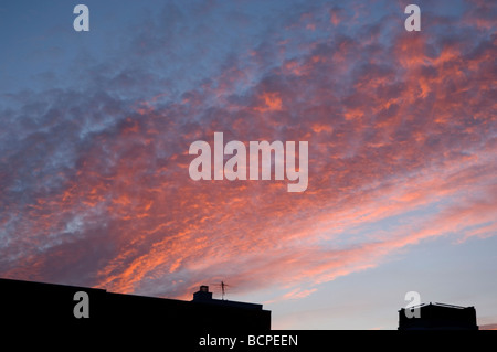 Nuvole rosa sulla città al tramonto Foto Stock