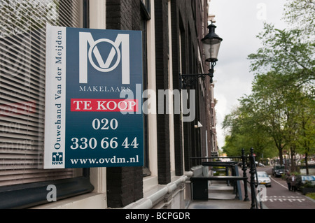 'Te Koop' (in vendita) Agente immobiliare segno su una casa in una strada di Amsterdam. Foto Stock