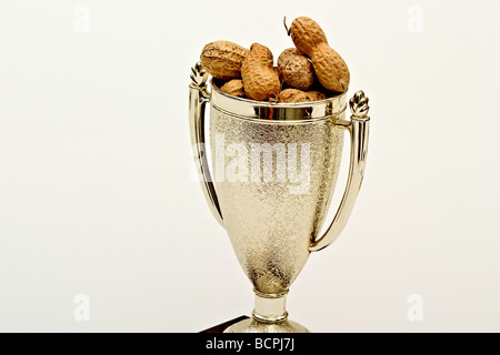 Un trofeo di tazza riempita con Arachidi in guscio Foto Stock