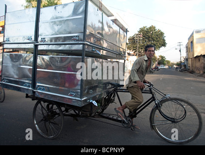 Carrello bicicletta pedali uomo enorme carico di metallo abbigliamento invernale tronchi Jaipur India Rajasthan Foto Stock