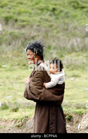 Il Tibetano madre bambino portando sulla sua schiena, Garzê tibetano prefettura autonoma, nella provincia di Sichuan, in Cina Foto Stock