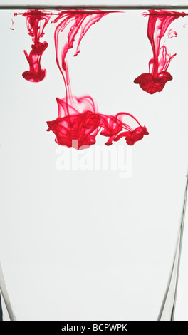 Colorati colorante alimentare gocce galleggianti in acqua per realizzare modelli astratti Foto Stock