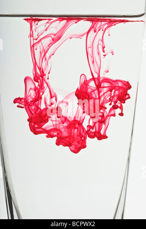 Colorati colorante alimentare gocce galleggianti in acqua per realizzare modelli astratti Foto Stock