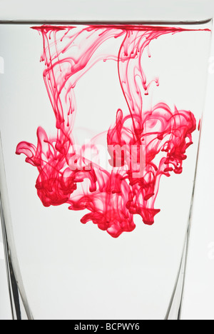 Colorati colorante alimentare gocce galleggianti in acqua per realizzare modelli astratti Foto Stock