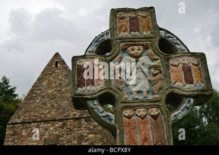 Ornati dipinti croce celtica con un depictino di San Patrizio nel centro,a un villaggio monastico nella Irish National Heritage Park, nella contea di Wexford. Foto Stock