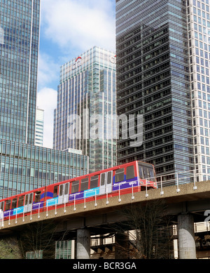 Un treno sulla Docklands Light Railway, passando attraverso il Canary Wharf area dei Docklands di Londra. Foto Stock