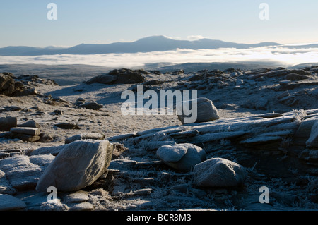 Coperto di brina rocce di ben sperare con Ben Klibreck nella distanza più basse nubi, Sutherland, Scotland, Regno Unito Foto Stock