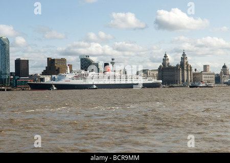 QE2 nave sul fiume Mersey Liverpool con il Liver Building e lo skyline in background Foto Stock