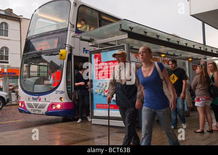 Una fermata degli autobus nel centro città di Norwich Norfolk Regno Unito con la gente di bagnare sotto la pioggia battente Foto Stock
