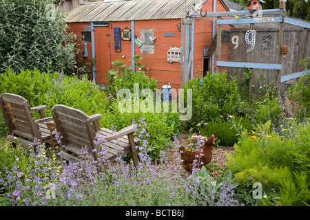Whimsical giardino nel cortile con erbe commestibili sedie rosse capannone e polli Amy Stewart s garden Foto Stock