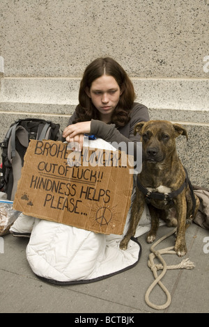 Giovani senzatetto donna panhandling su Broadway nel Quartiere Finanziario di New York City Foto Stock