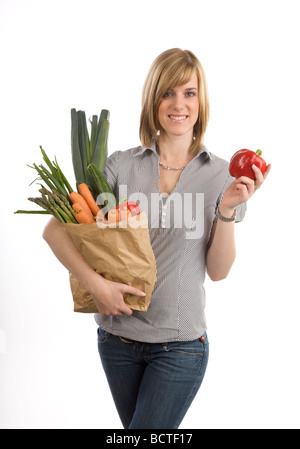 Giovane donna tenendo un sacchetto di verdure Foto Stock