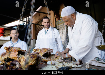 L'uomo vendita di deliziosi piatti a base di carne di agnello in un vicolo del mercato (souk o souq) nella città vecchia (a) Medina di Marrakech, Marocco. Foto Stock