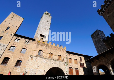 Torri medievali in Piazza del Duomo con la facciata del Palazzo del Podestà, San Gimignano, Toscana, Italia Foto Stock