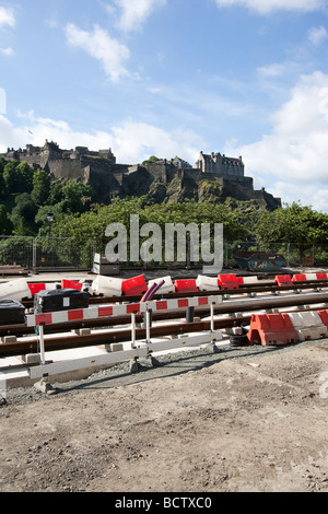 Il tram funziona su Princess street nella capitale Scotlands Edimburgo. Sovrastato dal Castello di Edimburgo situato su Castle Rock Foto Stock