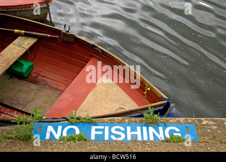 Nessun segno di pesca sulle sponde del fiume Tamigi a sunbury, middlesex in Inghilterra, con una piccola barca a remi in background Foto Stock