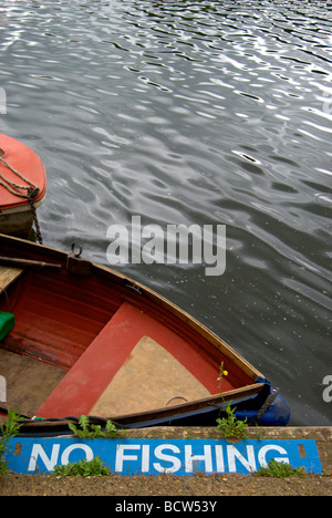 Nessun segno di pesca sulle sponde del fiume Tamigi a sunbury, middlesex in Inghilterra, con una piccola barca a remi in background Foto Stock