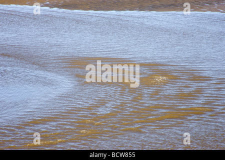 Acqua di mare si ritira e lascia le onde di marea & Increspature nella sabbia Foto Stock