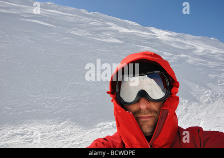 Giovane con gli occhiali di protezione pronto per lo stile libero azione sci dalla cima di una montagna Foto Stock