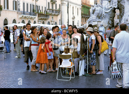 Uomo di disegno di un ritratto di una ragazza in un gruppo, Piazza Navona, Roma, Lazio, l'Italia, Europa Foto Stock