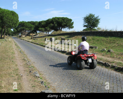 Persona che guida la moto sul antico romano via appia antica, Roma, Italia Foto Stock