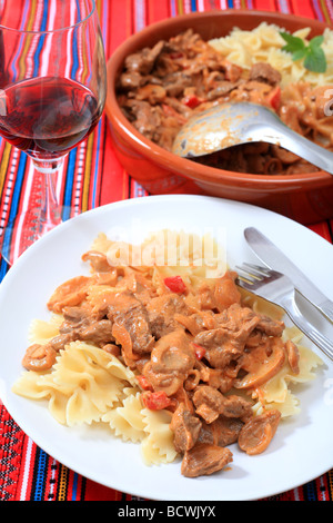 Una cena a base di carne di manzo stroganoff con pasta e vino Foto Stock