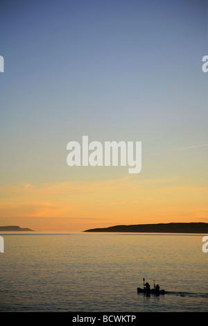 Canoisti paddling da Elgol sul Loch Scavaig verso l'isola di Soay al crepuscolo, Isola di Skye in Scozia Foto Stock