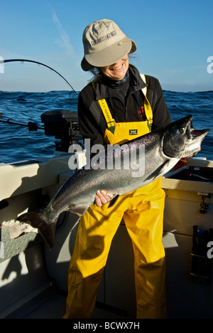 Felice pescatore femmina azienda appena catturati pacifico Salmone Chinook da Ucluelet BC Foto Stock