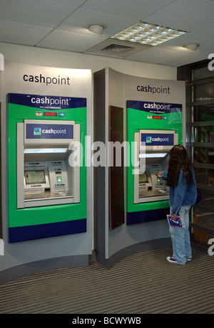 Donna che utilizza la Lloyds TSB Bank bancomat, Christchurch, Dorset, England, Regno Unito Foto Stock