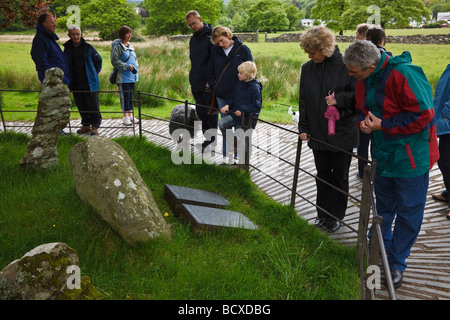 I turisti la lettura dell'iscrizione sul Gelert la sua tomba a Beddgelert, Parco Nazionale di Snowdonia, Gwynedd, Galles Foto Stock