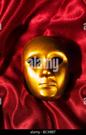 Maschera d'oro su sfondo rosso Foto Stock